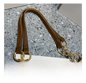Detail of high-quality brown leather strap with golden chain on a large tote bag