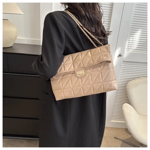 Detail of khaki quilted shoulder bag with geometric stitching and gold chain strap
