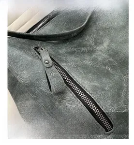 Nahaufnahme der grauen Vintage-Ledertasche mit Metallreißverschluss und Details