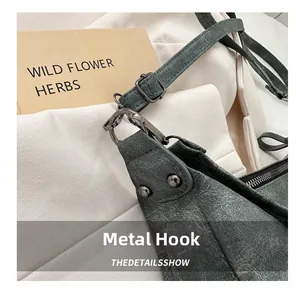 Detail von Metallhaken und Niete an der dunkelgrauen Ledertasche im Vintage-Look