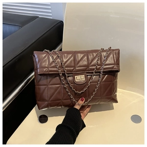 Detail of dark brown quilted crossbody bag with gold metal twist lock and chain strap
