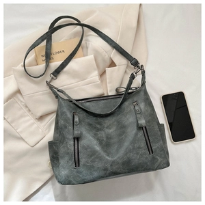 Détails du sac cabas gris avec deux fermetures éclair et finition mate vintage élégante