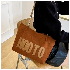 Detailed view of brown velvet tote bag with large HOOTO letter patch embroidery