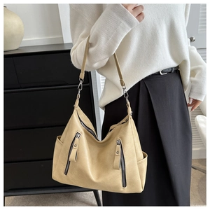 Détail du grand sac cabas beige avec fermetures éclair verticales et texture similicuir