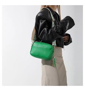 Close-up of green lychee leather texture and ethnic style embroidered wide shoulder strap