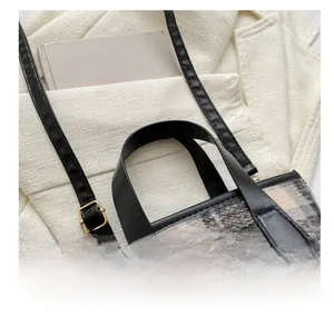 Close-up of black and white plaid wool tote bag with premium leather handles