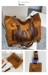 Detail of brown suede tote bag with HOOTO letter patch and metal chain leather strap