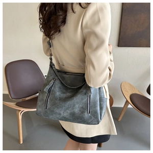 Detailansicht der grauen Vintage-Schultertasche mit Ledertextur und Metallreißverschlüssen