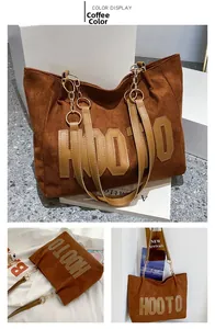 Detail of coffee brown tote bag with HOOTO letter print and metal chain strap