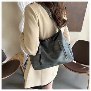 Détail du grand sac cabas gris foncé avec fermetures éclair porté par un mannequin