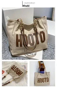 Detail of khaki tote bag with HOOTO lettering, suede texture, and chain leather strap