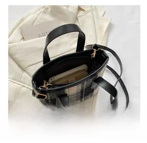 Interior capacity of the plaid wool handbag showing space for a phone and wallet