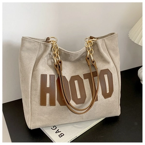 Detail of hooto large tote bag showing gold chain shoulder strap and suede texture