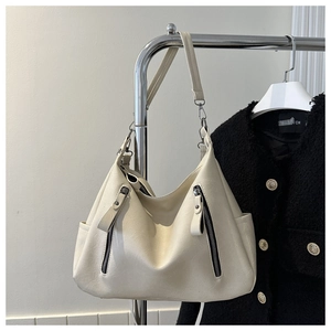 Detail of off-white large capacity tote bag featuring dual zippers and leather texture