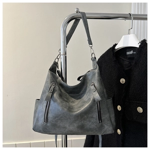 Detail of vintage gray faux leather tote bag with vertical zippers and silver hardware