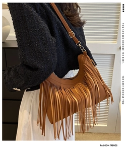 Detail of caramel brown hobo bag featuring stylish fringe and adjustable strap