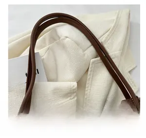 Detail of leather tote bag with soft shoulder straps and cute plush bear pendant