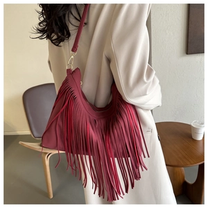 Close-up of deep red hobo bag with long bohemian tassels and gold metal hardware