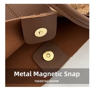 Detail of high-quality golden magnetic snaps on a brown PU leather tote bag with plush trim