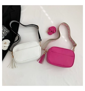 Detail of white and magenta litchi PU leather crossbody bags with jacquard wide straps
