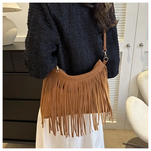 Detail view of brown faux leather fringe on bohemian style crescent crossbody bag