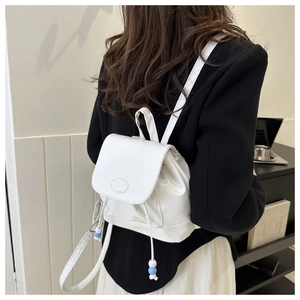 Vue détaillée d'un mini sac à dos en cuir PU blanc avec perles bleues sur le cordon