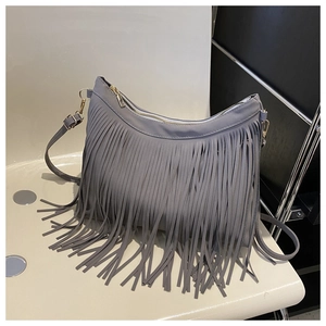Detail of grey fringed crossbody bag with gold metal zipper and suede texture finish