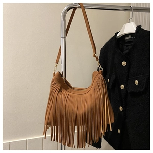 Detail of bohemian brown suede shoulder bag featuring long fringe and metal zipper