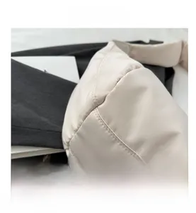 Gros plan détaillé du sac matelassé crème montrant les fines coutures doubles en nylon