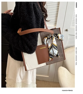 Detail of color-block tote bag featuring patterned scarf and fashion leather patch