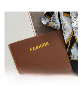 Close-up of brown textured leather pocket with FASHION print and vintage silk scarf detail