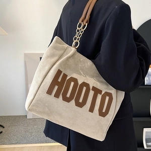 Large beige suede tote bag with brown embroidered letters and gold chain shoulder strap