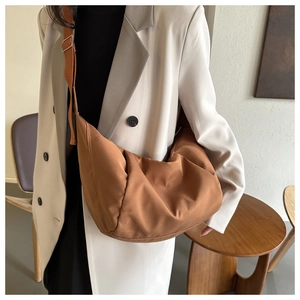 Détail du sac demi-lune en nylon caramel avec large bandoulière réglable portée