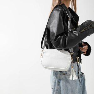 White lychee leather crossbody bag with geometric woven wide strap and tassel