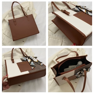 Detail view of large capacity tote bag with internal compartments and silk scarf handles