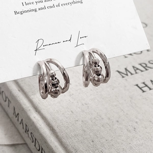 Three-layer hollow silver-plated earrings with multi-faceted beads in a minimalist style