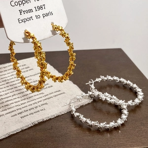 Exaggerated spiral hoop earrings with crumpled metal texture in gold and silver finish
