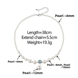 Detail view of pearl necklace with blue gemstone pendant and silver extension chain