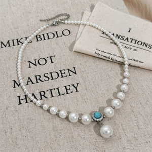 Elegant vintage pearl necklace featuring a turquoise center stone and a large drop pearl