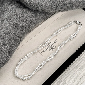 Collier classique double rang de perles avec fermoir argenté sur présentoir de luxe