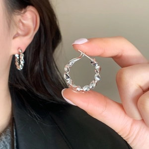 Minimalist silver twisted hoop earrings with textured finish for a trendy everyday style