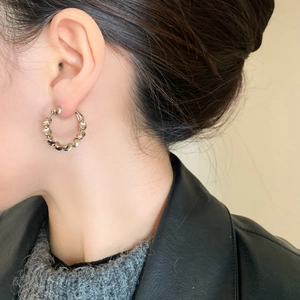 Minimalist silver twisted metal hoop earrings with vintage wavy texture on model