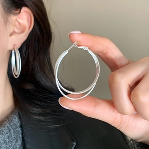 Matte silver double hoop earrings with a modern minimalist layered circular design