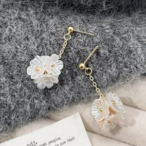 Boucles d'oreilles pendantes dorées avec grappes de fleurs blanches irisées et pompons