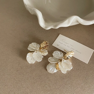 Detail of layered shell flower petals with a gold finish and cubic zirconia stud