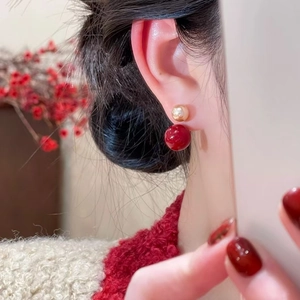 Elegant red pearl and gold double stud earrings worn by model in a festive setting