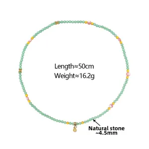 Close-up of handmade natural stone necklace with green beads and gold charms