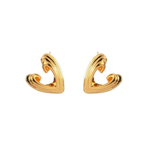 Macro view of textured gold heart stud earrings with vertical ribbed patterns