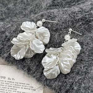 Élégantes boucles d'oreilles pétales en argent et perles blanches sur fond sombre