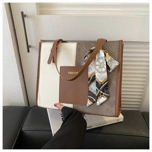 Detail of color-block tote bag with FASHION leather pocket and decorative silk scarf
